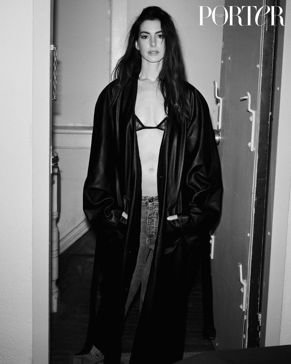 Anne Hathaway trägt einen Mantel von Balenciaga, BH von Gucci, Jeans von Bottega Veneta, via NET-A-PORTER.com