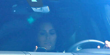Kim Kardashian schaut beim Autofahren aufs Handy