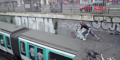 Mann springt auf fahrende U-Bahn