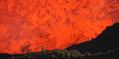 Mann steigt in Vulkankrater