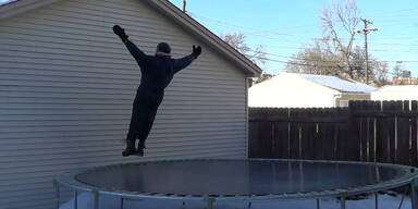 Mann springt auf gefrorenes Trampolin