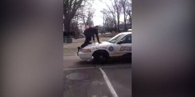Mann läuft über Polizeiauto