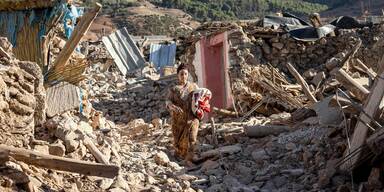 Frau vor Trümmern nach Erdbeben in Marokko