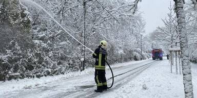 Feuerwehr Kritzendorf spritzt Schnee mit Wasser von Bäumen