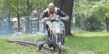 Mann fuhr mit Vespa auf Schienen der Liliputbahn im Prater