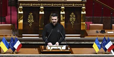 Ukraine’s President Volodymyr Zelensky (down) delivers a speech in the French National Assembly