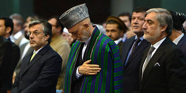 Afghan President Hamid Karzai (C) and Afghan presidential candidate Abdullah Abdullah (R)