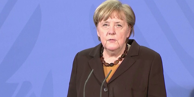 Bundeskanzlerin Angela Merkel vor blauem Hintergrund