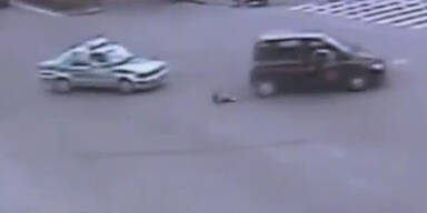 Kind fällt aus fahrendem Auto auf Straße