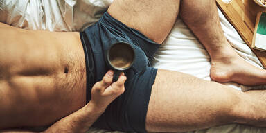 mann in unterhose und kaffee im bett