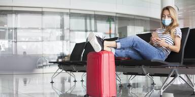 Frau am Flughafen mit Koffer