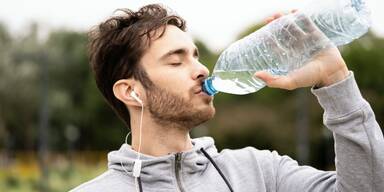 Mann trinkt aus einer Wasserflasche