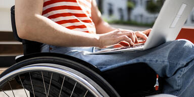 Rollstuhlfahrer mit Laptop