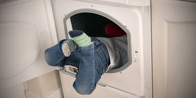 Kind in Wäschetrockner/Waschmaschine