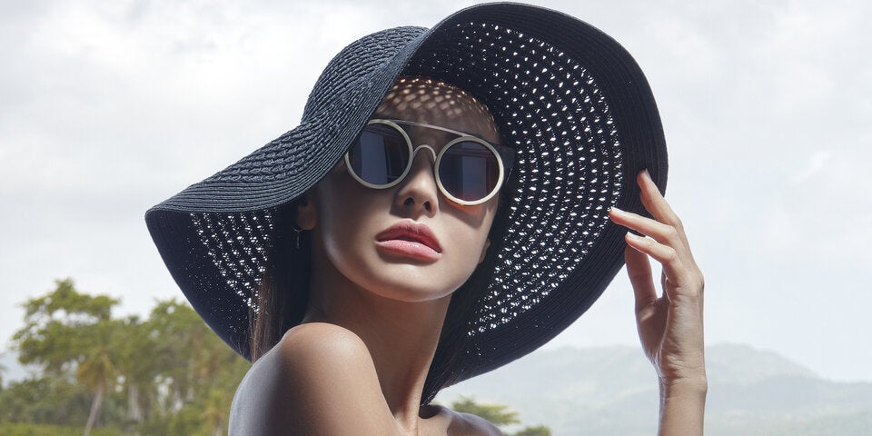 Frau mit Sonnenbrille und Sonnenhut