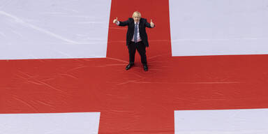 Englands Premierminister posiert auf einer überdimensional großen England-Fahne