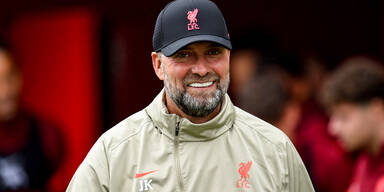 Liverpool-Coach Jürgen Klopp (ohne Brille) lächelt in die Kamera