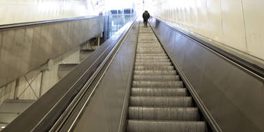 Mann tritt auf Frau auf U-Bahn-Rolltreppe ein