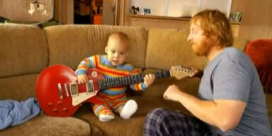 Babymozart spielt mit Vater Gitarre
