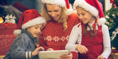 Frau mit Kindern vor Tablet weihnachtlich