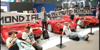 Klimaaktivisten kleben sich auf Pariser Auto-Messe an Sportwagen fest