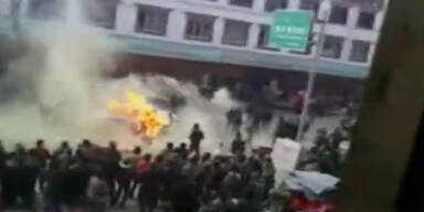 China: Polizei tritt auf brennenden Mann ein