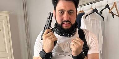 Yusif Eyvazov posiert mit Waffe, Halsband und gefesselten Armen