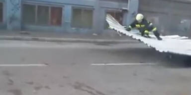 Feuerwehrmann schwebt auf Blechdach