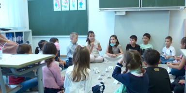 Kinder sitzen in einer Gruppe am Boden