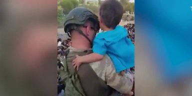 Soldat mit Kind auf dem Arm