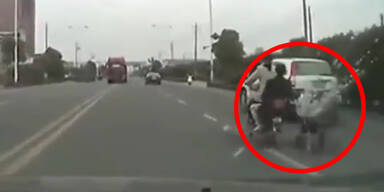 China: Frau zieht Kinderwagen mit Moped