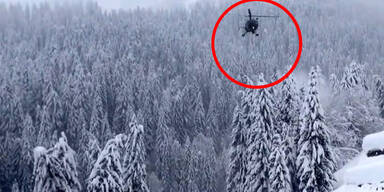 Hubschrauber blasen Schnee von Bäumen