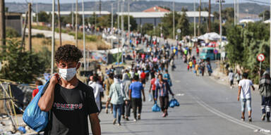 Flüchtlinge aus Moria auf den Straßen von Lesbos mit Schutzmasken