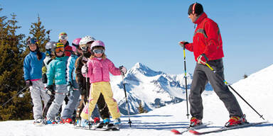 schuelergruppe im skikurs auf berg